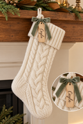 Design mockup: cream cable-knit stocking, personalized wood tag and sage ribbon bow.