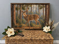 Framed vintage painting of a whitetail buck walking through pine woods, styled with magnolias.